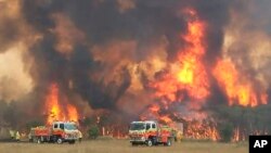 FILE - Firefighters try to protect homes around Charmhaven, New South Wales, in this image dated Dec. 30, 2019, and provided by NSW Rural Fire Service via their twitter account.