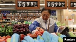 资料照片：一名顾客在北京一家超市购买蔬菜。(2024年10月17日)