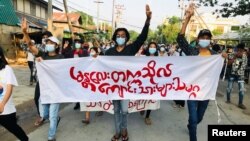 និស្សិត​នាំ​គ្នា​កាន់​បដា​មួយ និង​លើក​ម្រាម​ដៃ​បី​ឡើង​ ខណៈ​ដែល​ពួកគេ​ចូលរួម​ធ្វើ​បាតុកម្ម​ប្រឆាំង​នឹង​រដ្ឋប្រហារ​យោធា​មីយ៉ាន់ម៉ា នៅ​ក្នុង​ទីក្រុង Mandalay ប្រទេស​មីយ៉ាន់ម៉ា ថ្ងៃទី១០ ខែឧសភា ឆ្នាំ២០២១។ 