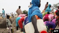 At the Jamam refugee camp, shows people gathering water at a man-made water hole, in South Sudan's Upper Nile state, where over 100,000 refugees have fled conflict in Sudan's Blue Nile state since September, June 15, 2012.