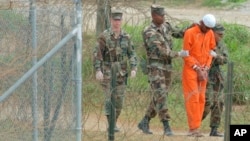 Seorang tahanan digiring oleh polisi militer untuk diinterogasi oleh pejabat militer di Kamp X-Ray di Pangkalan Angkatan Laut AS di Teluk Guantanamo, Kuba (foto: dok). 