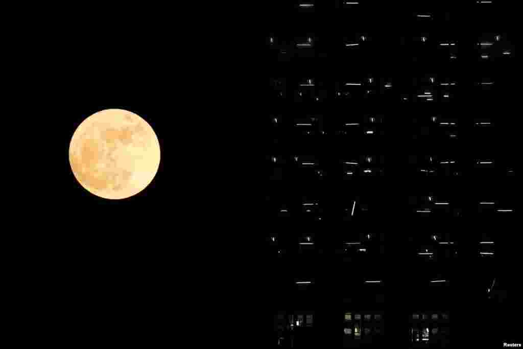 The supermoon is seen behind a building under construction in Hong Kong.