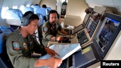 Dua anggota TACCO TNI AL membantu pencarian pesawat AirAsia QZ 8501 yang hilang menggunakan pesawat CN235 di atas Karimun Jawa, di Laut Jawa, 28 Desember 2014 di foto yang diambil oleh Antara Foto. 