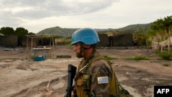 FILE - A UN soldier patrols the area surrounding the village of Kafe, at Lake Albert in Ituri, March 27, 2018. Conflict between members of the Lendu and Hema tribes has caused the instability within the Ituri region and thousands of Hema people to flee.