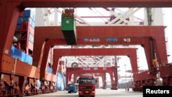 Trucks transport containers at a port in Qingdao, Shandong province, China, Apr. 8, 2018. 