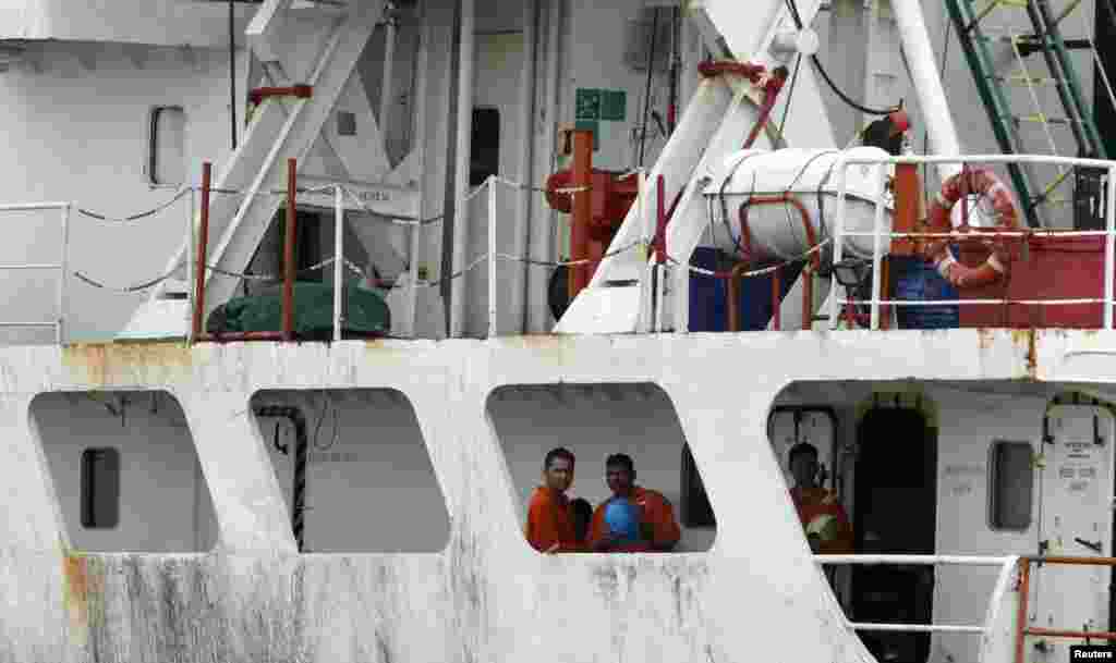 Crew members of the Panama-flagged cargo ship MV Asphalt Venture freed by pirates look out from the ship at the Kenyan Port of Mombasa, April 28, 2011.