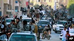 FILE - Fighters from the Islamic State group parade in Raqqa, north Syria, June 30, 2014. A former British spy chief said at the time that militants had more than doubled the recruitment of foreign fighters to as much as 31,000 over an 18-month period.