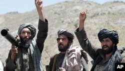 FILE - Taliban fighters react to a speech by their senior leader in the Shindand district of Herat province, Afghanistan. 