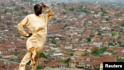 In this file photo, Yinka Sotomi stands atop Oluma Rock, a spiritual site for the Yoruba tribe, overlooking the city of Abeokuta in southern Nigeria, April 16, 2007. (REUTERS/Finbarr O'Reilly)