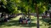 FILE - Police officers sit in the shade of a tree on a hot, humid day at a public park in Yangon, Myanmar, March 17, 2016.