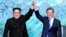 North Korean leader Kim Jong Un, left, and South Korean President Moon Jae-in raise their hands after signing a joint statement at the border village of Panmunjom in the Demilitarized Zone, South Korea, April 27, 2018.