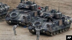 FILE - A U.S. Army soldier gestures to a fellow solider as they participate in annual military drills in Yeoncheon, South Korea, near the border with North Korea, April 11, 2013. 
