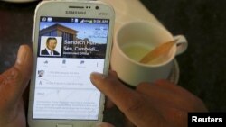 រូបឯកសារ៖ អ្នក​ប្រើប្រាស់​ទូរស័ព្ទ​ទំនើប smartphone មួយ​ចុច​មើល​ទំព័រ​ហ្វេសប៊ុក​របស់​លោក​នាយរដ្ឋមន្ត្រី ហ៊ុន សែន នៃ​ប្រទេស​កម្ពុជា​ក្នុង​ពេល​ទទួល​អាន​អាហារ​ពេល​ព្រឹក​នៅ​ក្នុង​ភោជនីយដ្ឋាន​មួយ​នៅ​កណ្តាល​រាជធានី​ភ្នំពេញ​កាល​ពី​ថ្ងៃ​ទី​៧ ខែ​តុលា ឆ្នាំ​២០១៥។