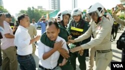 កងកម្លាំង​នគរបាល បាន​ព្យាយាម​រារាំង​សកម្មជន​កូនភ្លោះ ជុំ ហួរ និង ជុំ ហួត មិន​ឱ្យ​ដាក់​កម្រងផ្កា រំឭក​វិញ្ញាណក្ខន្ធ​លោក កែម ឡី នៅ​ស្ថានីយ៍​ប្រេងឥន្ធនៈ​កាល់តិច នៅ​ស្តុប​បូកគោ ខណ្ឌចម្ការមន រាជធានី​ភ្នំពេញ នៅ​ព្រឹកថ្ងៃទី១០ ខែកក្កដា ឆ្នាំ២០១៩។ (អូន ឆេងប៉រ/VOA)