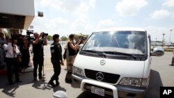 A van drives four refugees from Australia out of Phnom Penh International Airport, in Phnom Penh, Cambodia, Thursday, June 4, 2015.