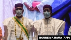 Le nouveau président du Niger Mohamed Bazoum et l'ancien président du Niger Mahamadou Issoufou lors de son investiture au Centre international de conférences de Niamey le 2 avril 2021.