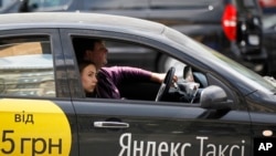 Seorang perempuan menggunakan Yandex taxi di Kiev, Ukraina, May 16, 2017. (Foto: dok). Yandex adalah perusahaan teknologi Rusia yang mengkhususkan diri pada layanan dan produk berbasis Internet.
