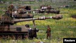 Israeli soldier stands by mobile artillery unit near town of Katzrin, Golan Heights, March 19, 2014.