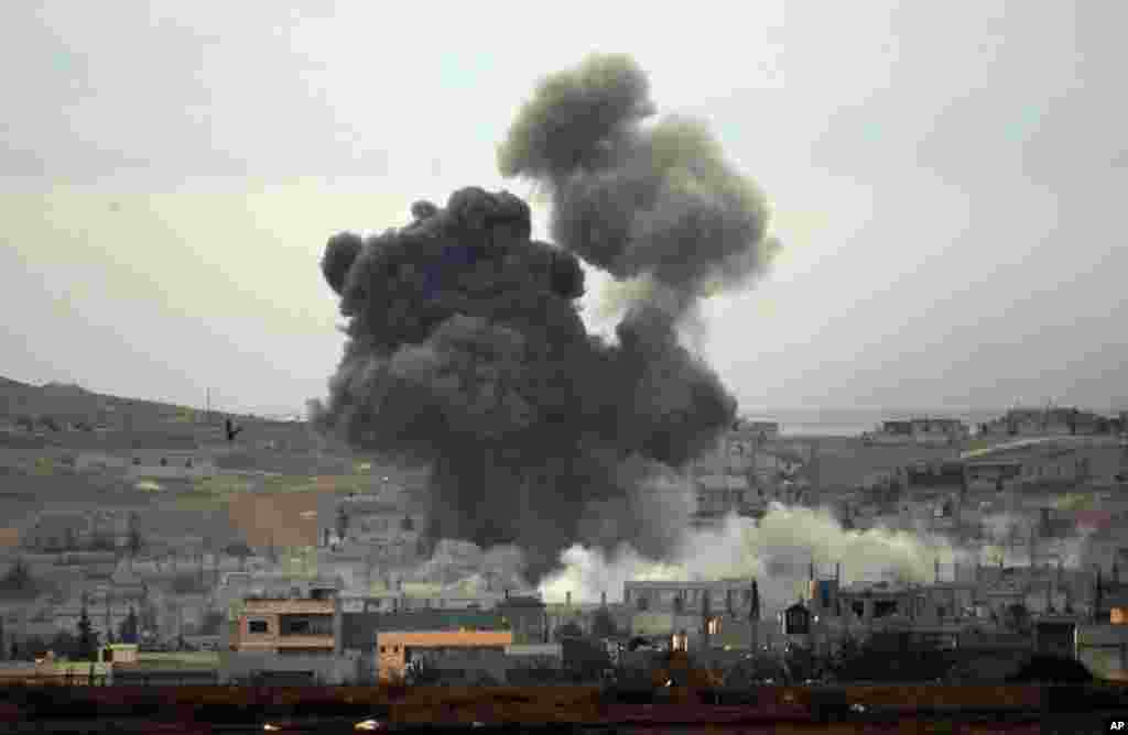 Thick smoke rises following an airstrike by the US-led coalition in Kobani, Syria, as seen from Mursitpinar on the outskirts of Suruc, Oct. 14, 2014.