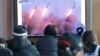People watch a TV showing file images of North Korea's missile launch during a news program at the Seoul Railway Station in Seoul, South Korea, Monday, March 10, 2020. 