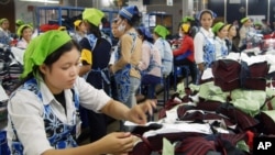 FILE - Cambodians work inside a factory in Phnom Penh, May 10, 2004 photo. 