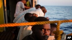 Les migrants se reposent sur le pont d'un bateau, après avoir été sauvés au large des côtes libyennes le 2 août 2018.