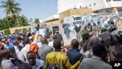 Security forces fire tear gas at people gathered outside a conference to discuss a transition to a civilian government in Bamako, Mali, Sept. 10, 2020. 