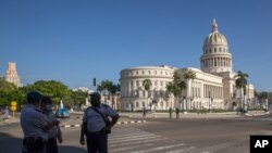 Police stand guard near the National Capitol building in Havana, Cuba, Monday, July 12, 2021, the day after protests against food shortages and high prices amid the coronavirus crisis.