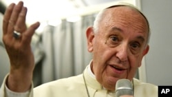 Pope Francis talks during a news conference on board a flight to return to Rome, Dec. 2, 2017, after a seven day trip to Myanmar and Bangladesh.