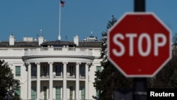 សេតវិមាន​ត្រូវ​បាន​គេ​ឃើញ​នៅ​ពី​ក្រោយ​ស្លាក​សញ្ញា​ឈប់​មួយ​ ប៉ុន្មាន​ថ្ងៃ​បន្ទាប់​ពី​ក្រុម​អ្នក​គាំទ្រ​របស់​ប្រធានាធិបតី​សហរដ្ឋអាមេរិក​លោក Donald Trump ឡោមព័ទ្ធ​វិមាន​សភា​ក្នុង​រដ្ឋធានី​វ៉ាស៊ីនតោន ថ្ងៃទី១០ ខែមករា ឆ្នាំ២០២១។ 