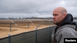 Dave Duttlinger stoji u krevetu svog kamioneta, gleda na zemljište koje je dao u zakup Dunns Bridge Solar LLC koji je izgradio solarne farme u Wheatfieldu, Indiana, SAD, 5. aprila 2024. REUTERS/Jim Vondruska
