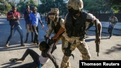 Police officers detain a man during protests against Haiti's President Jovenel Moise, in Port-au-Prince, Feb. 8, 2021.