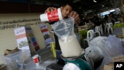 เกษตรกรชั่งตวงข้าวให้ลูกค้าในตลาดขายตรงที่กรุงเทพมหานคร ในช่วงที่ราคาข้าวตกต่ำเมื่อปี 2016 (ที่มา: แฟ้มภาพ/AP)