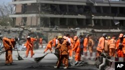 Radnici javnih preduzeća čiste ulicu ispred nemačke ambasade nakon samoubilačkog napada u Kabulu, 31. maja 2017.