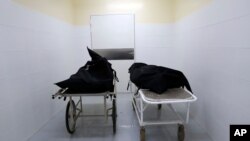 The corpses of two people who died of COVID-19 lie inside the morgue of the National Hospital Nacional, before their relatives come for them, in Itagua, Paraguay, Sept. 7, 2020.