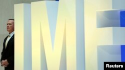 A security personnel stands next to International Monetary Fund logo at IMF headquarters in Washington, April 19, 2017. 