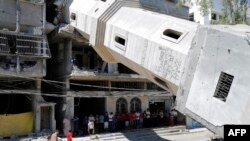 Palestinian Muslim worshipers attend Friday noon prayer beneath the fallen minaret of the al-Susi mosque in Gaza City on Sept. 12, 2014 which was hit by Israeli strikes during the latest round of deadly fighting with Hamas militants. 
