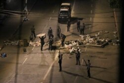 Armed police remove makeshift blockages set up by protesters as they patrol streets in downtown Yangon, Myanmar, March 21, 2021.