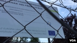 Tanda yang menunjukkan kamp pengungsi di Bicske didukung oleh Uni Eropa. Hungaria dengan setengah hati menampung pencari suaka. Pemerintah berharap referendum mendatang akan mendesak Uni Eropa untuk mereformasi kebijakan migrasinya (foto: L. Ramirez/VOA)