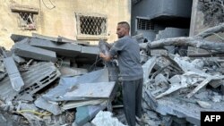 Mpalestina akikagua jengo lililoharibiwa na vita Gaza. 