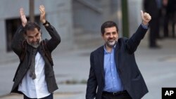 Jordi Cuixart, president of the Catalan Omnium Cultural organization, left, and Jordi Sanchez, president of the Catalan National Assembly, wave to supporters on arrival at the national court in Madrid, Spain, Oct. 16, 2017.