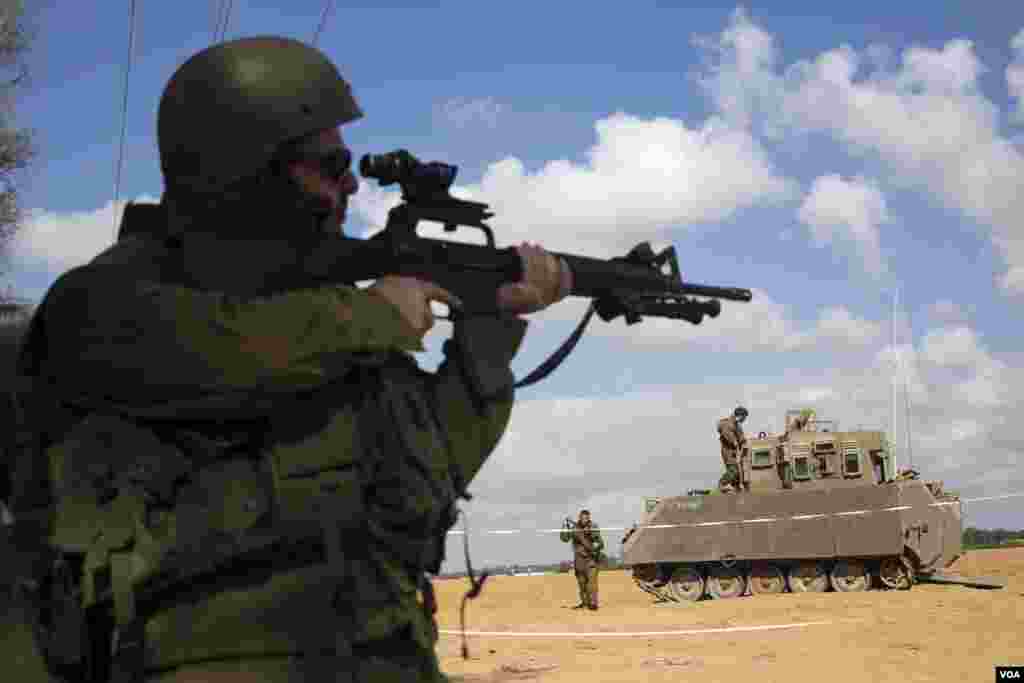 An Israeli soldier looks through the scope of his weapon outside the southern Gaza Strip, July 17, 2014.