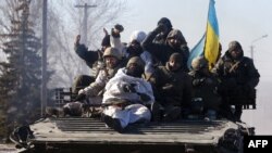 Ukraine -- Ukrainian soldiers ride an armoured personnel carrier (APC) as they leave the eastern Ukrainian city of Debaltseve, 18Feb2015