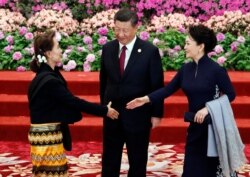 Myanmar State Counselor Aung San Suu Kyi, left, arrives to attend a welcoming banquet for the Belt and Road Forum hosted by Chinese President Xi Jinping, center, and his wife Peng Liyuan at the Great Hall of the People in Beijing, April 26, 2019.