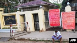 FILE - A man sits in front of Insein prison in Yangon on April 12, 2021, while waiting to visit inmates ahead of the long holiday stretch for the Myanmar New Year, also known as Thingyan, as the country remains in turmoil after the February military coup.