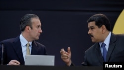 FILE - Venezuela's President Nicolas Maduro, right, speaks with Venezuela's Vice President Tareck El Aissami in Caracas, Venezuela, Feb. 20, 2018. 