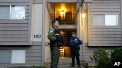 Petugas polisi setempat menjaga apartemen di mana tersangka penembak Chris Harper Mercer tinggal di Roseburg, Oregon, Jumat (2/10).