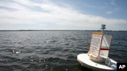 FILE - A floating marker indicates the border between the U.S. and Canada on Lake Champlain, in Vermont, June 25, 2008.