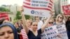 FILE PHOTO: Protesters hold signs against U.S. President Donald Trump's limited travel ban, approved by the U.S. Supreme Court, in New York City, on June 29, 2017.