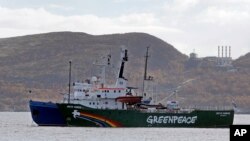 Kapal Greenpeace 'Arctic Sunrise' dikawal oleh kapal pengawal pantai dari basis militer Rusia di Severomorsk, Semenanjung Kola, Rusia (24/9). 